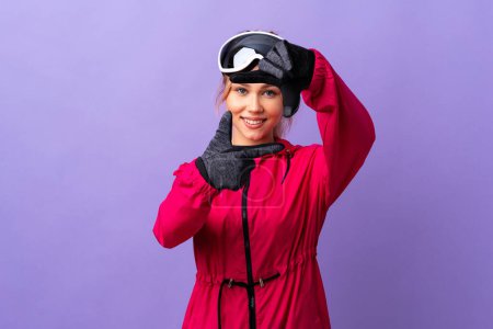Photo for Skier teenager girl with snowboarding glasses over isolated purple background focusing face. Framing symbol - Royalty Free Image