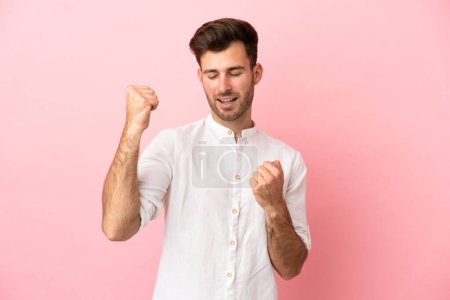 Photo for Young caucasian handsome man isolated on pink background celebrating a victory - Royalty Free Image