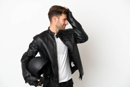 Foto de Joven hombre caucásico con un casco de moto aislado sobre fondo blanco se ha dado cuenta de algo y la intención de la solución - Imagen libre de derechos