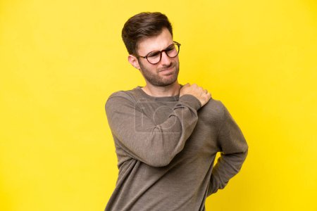 Photo for Young caucasian man isolated on yellow background suffering from pain in shoulder for having made an effort - Royalty Free Image