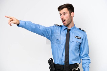 Foto de Young police caucasian man isolated on white background pointing away - Imagen libre de derechos