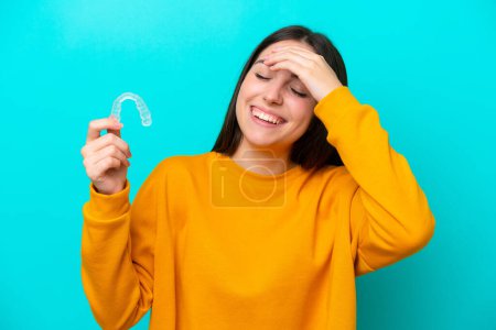 Téléchargez les photos : Young caucasian woman holding invisible braces isolated on blue background has realized something and intending the solution - en image libre de droit