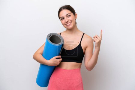Photo for Young sport girl going to yoga classes while holding a mat isolated on white background pointing up a great idea - Royalty Free Image