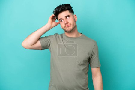 Photo for Young caucasian man isolated on blue background with an expression of frustration and not understanding - Royalty Free Image