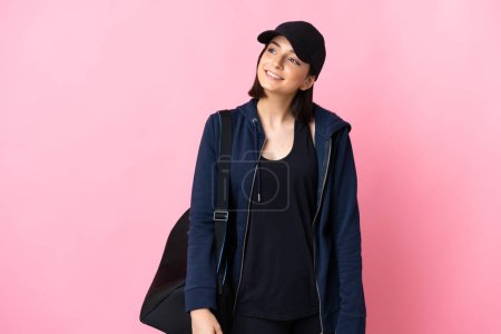 Photo for Young sport woman with sport bag isolated on pink background thinking an idea while looking up - Royalty Free Image