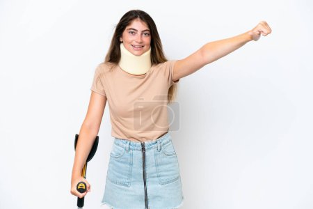 Téléchargez les photos : Jeune femme caucasienne portant une attelle de cou et une béquille isolée sur fond blanc donnant un geste pouce vers le haut - en image libre de droit