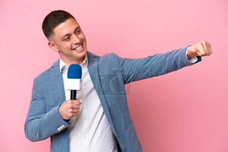 Téléchargez les photos : Jeune présentateur brésilien homme isolé sur fond rose donnant un pouce geste - en image libre de droit