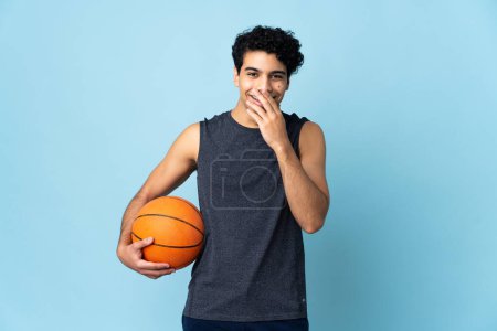 Téléchargez les photos : Vénézuélien joueur de basket homme sur fond isolé heureux et souriant couvrant la bouche avec la main - en image libre de droit