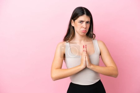 Photo for Young Italian woman isolated on pink background keeps palm together. Person asks for something - Royalty Free Image