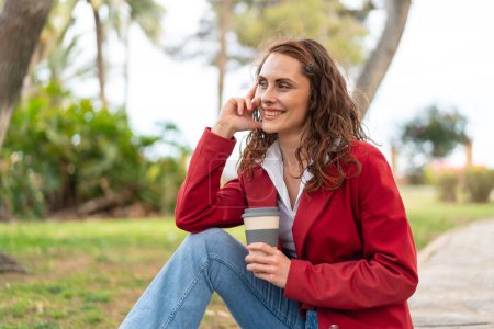 Photo for Young caucasian woman at outdoors holding a take away coffee - Royalty Free Image