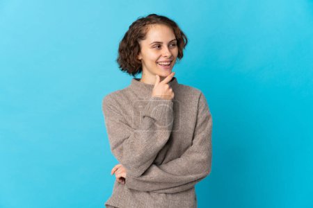 Téléchargez les photos : Jeune femme anglaise isolée sur fond bleu regardant vers le côté et souriant - en image libre de droit