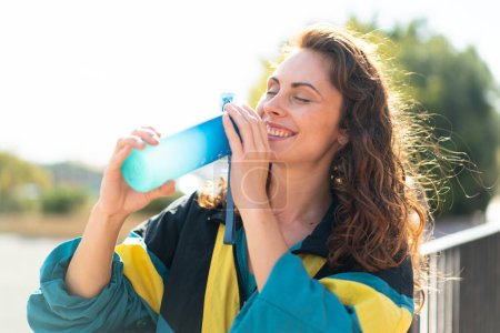 Téléchargez les photos : Jeune femme sportive en plein air avec une bouteille d'eau - en image libre de droit