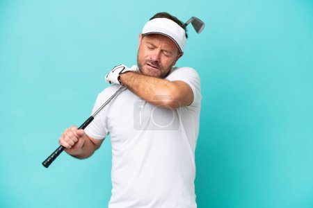 Téléchargez les photos : Moyen âge joueur de golf caucasien homme isolé sur fond bleu souffrant de douleur à l'épaule pour avoir fait un effort - en image libre de droit