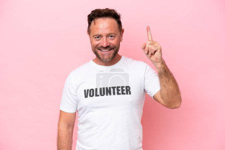 Middle age volunteer man isolated on pink background isolated on pink background pointing up a great idea