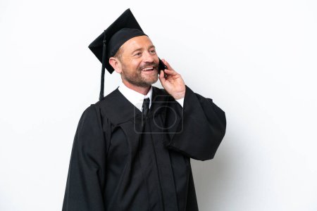 Foto de Graduado universitario de mediana edad aislado sobre fondo blanco manteniendo una conversación con el teléfono móvil - Imagen libre de derechos