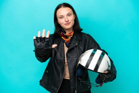 Photo for Young caucasian woman with a motorcycle helmet isolated on blue background counting five with fingers - Royalty Free Image