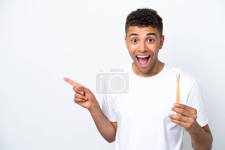 Photo for Young Brazilian man brushing teeth isolated on white background surprised and pointing finger to the side - Royalty Free Image