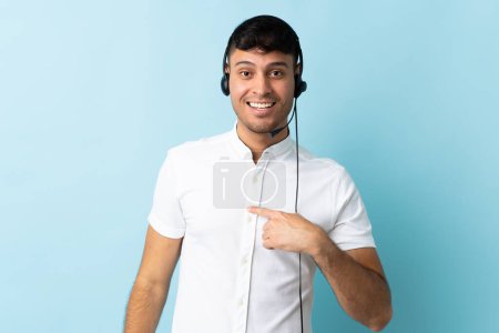 Photo for Telemarketer Colombian man working with a headset over isolated background with surprise facial expression - Royalty Free Image