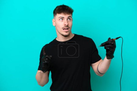 Photo for Tattoo artist caucasian man isolated on blue background thinking an idea pointing the finger up - Royalty Free Image