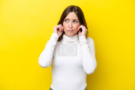 Photo for Young caucasian woman isolated on yellow background frustrated and covering ears - Royalty Free Image