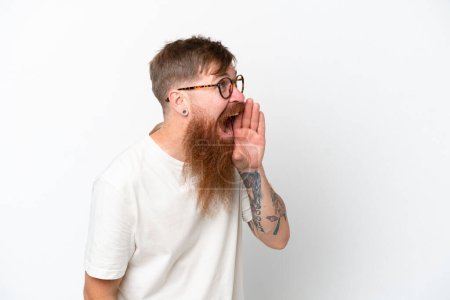 Photo for Redhead man with long beard isolated on white background shouting with mouth wide open to the side - Royalty Free Image