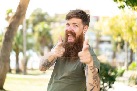 Photo for Redhead man with beard pointing to the front and smiling - Royalty Free Image
