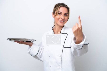 Foto de Joven chef mujer con bandeja aislada sobre fondo blanco haciendo el gesto que viene - Imagen libre de derechos