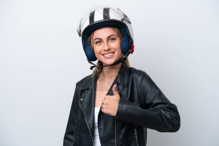 Téléchargez les photos : Jeune femme caucasienne avec un casque de moto isolé sur fond blanc donnant un geste pouce vers le haut - en image libre de droit