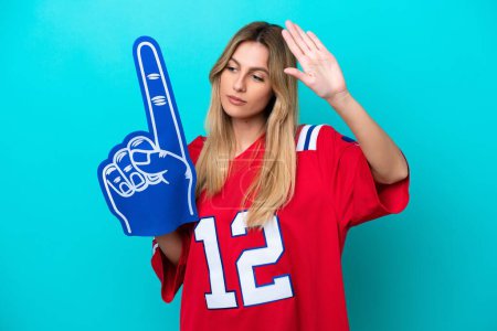 Uruguayan sports fan woman isolated on blue background making stop gesture and disappointed