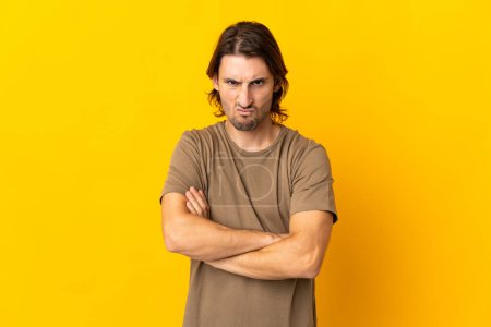 Photo for Young handsome man isolated on yellow background with unhappy expression - Royalty Free Image