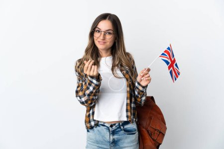 Young Romanian woman holding an United Kingdom flag isolated on white background making money gesture