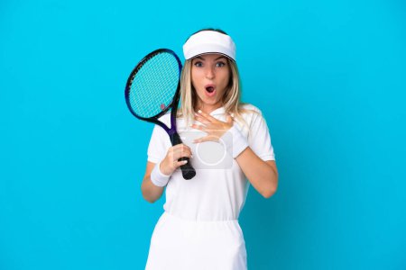 Photo for Young tennis player Romanian woman isolated on blue background surprised and shocked while looking right - Royalty Free Image