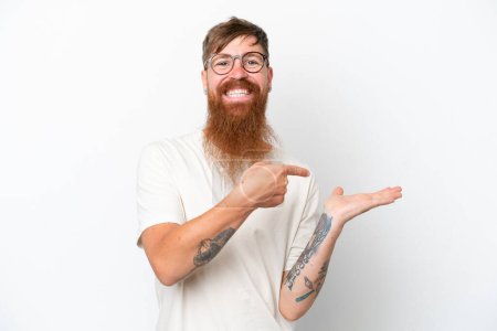 Photo for Redhead man with long beard isolated on white background holding copyspace imaginary on the palm to insert an ad - Royalty Free Image