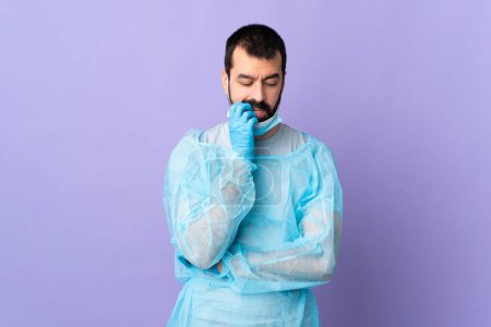Téléchargez les photos : Chirurgien homme avec barbe avec uniforme bleu sur fond violet isolé ayant des doutes - en image libre de droit