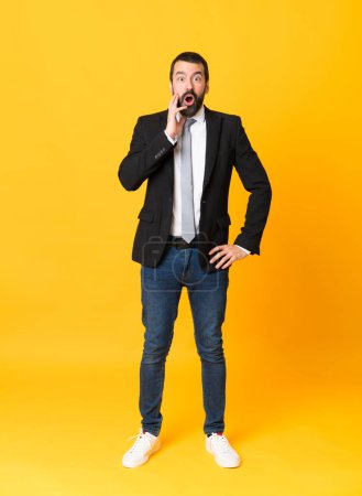 Photo for Full-length shot of business man over isolated yellow background with surprise and shocked facial expression - Royalty Free Image