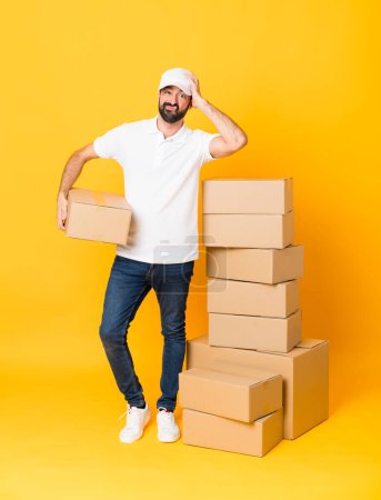 Photo for Full-length shot of delivery man among boxes over isolated yellow background with an expression of frustration and not understanding - Royalty Free Image