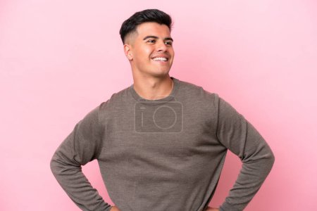 Photo for Young caucasian handsome man isolated on pink background posing with arms at hip and smiling - Royalty Free Image