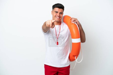 Téléchargez les photos : Jeune homme beau isolé sur fond blanc avec un équipement de sauveteur et pointe du doigt vers vous - en image libre de droit