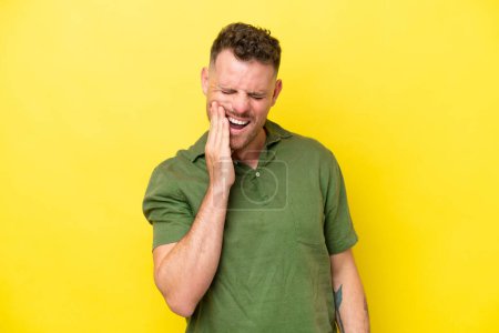 Photo for Young caucasian handsome man isolated on yellow background with toothache - Royalty Free Image