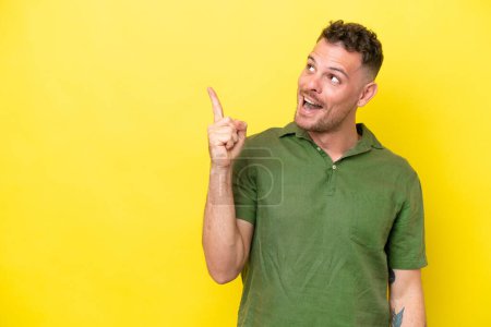 Photo for Young caucasian handsome man isolated on yellow background intending to realizes the solution while lifting a finger up - Royalty Free Image