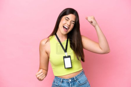 Téléchargez les photos : Young Brazilian woman with ID card isolated on pink background celebrating a victory - en image libre de droit