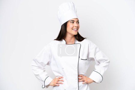 Foto de Joven chef brasileña aislada sobre fondo blanco posando con los brazos en la cadera y sonriendo - Imagen libre de derechos