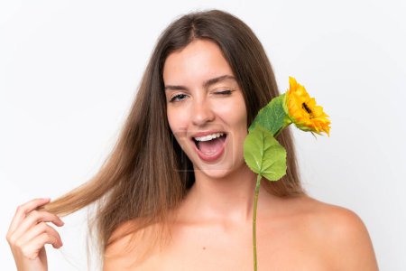 Photo for Young caucasian woman isolated on white background holding a sunflower while smiling. Close up portrait - Royalty Free Image
