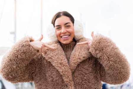 Téléchargez les photos : Jeune femme portant des manchons d'hiver à l'extérieur fier et satisfait de soi - en image libre de droit