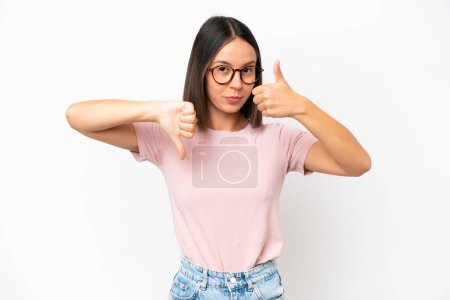 Photo for Young caucasian woman isolated on white background making good-bad sign. Undecided between yes or not - Royalty Free Image