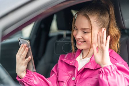 Foto de Joven chica bonita dentro de un coche usando el teléfono móvil - Imagen libre de derechos
