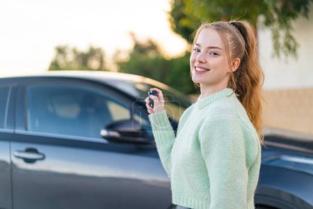 Téléchargez les photos : Jeune jolie fille tenant des clés de voiture à l'extérieur - en image libre de droit
