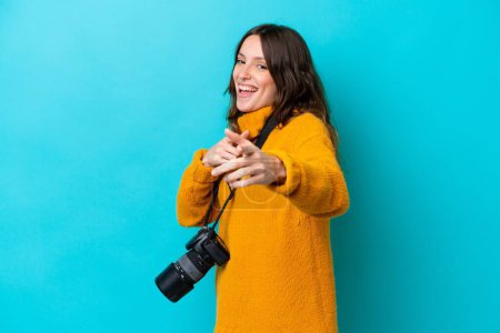 Photo for Young photographer woman isolated on blue background pointing to the front and smiling - Royalty Free Image