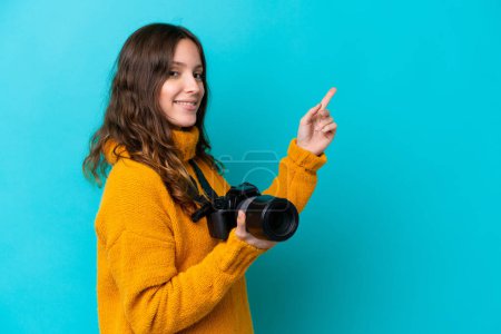 Photo for Young photographer woman isolated on blue background pointing finger to the side - Royalty Free Image