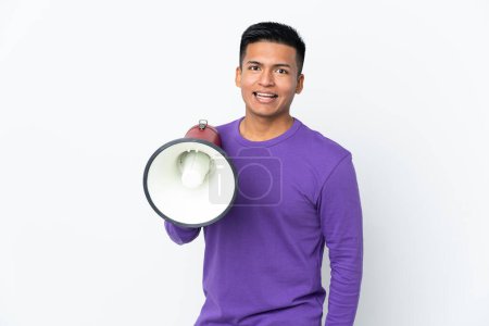 Foto de Joven ecuatoriano aislado sobre fondo blanco sosteniendo un megáfono y con expresión sorpresiva - Imagen libre de derechos